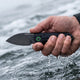 Frogman folding knife in hand in the water